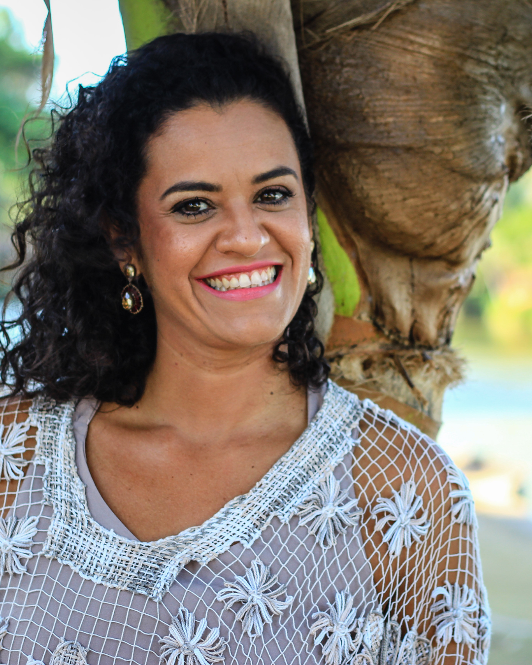 Foto de Karinne Bandeira sorrindo, autora da série 'Ancorando o Ser na Terra' - livros e estampas vibracionais